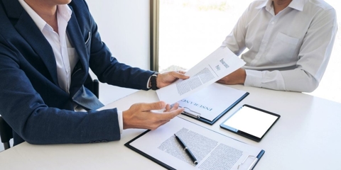 two people discussing insurance paperwork