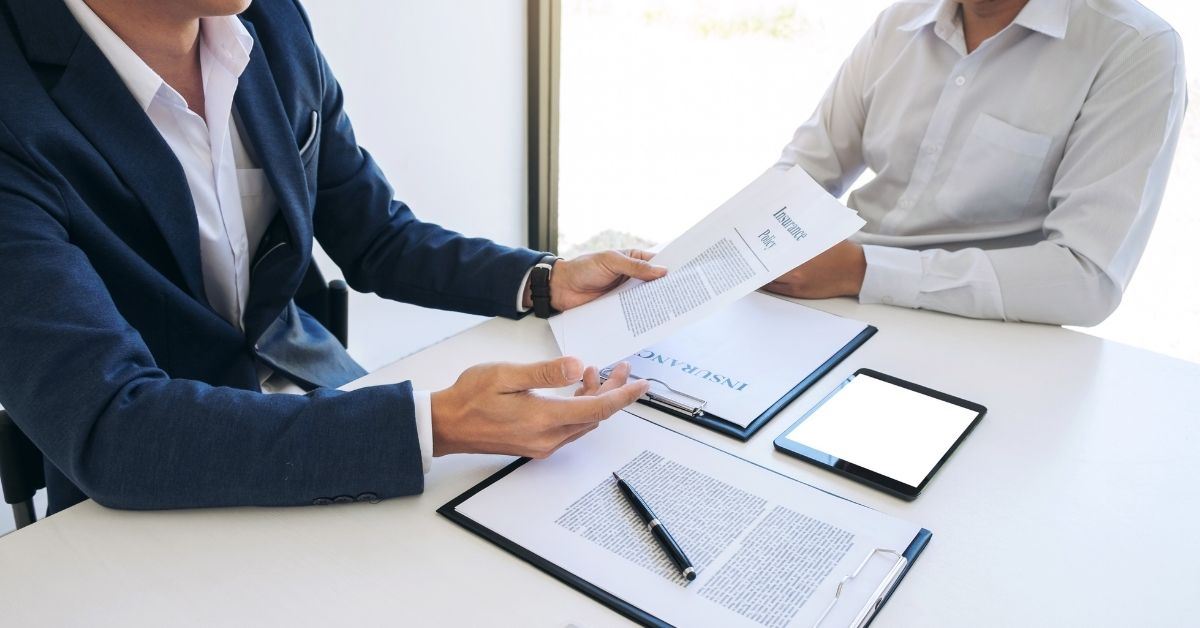 two people discussing insurance paperwork